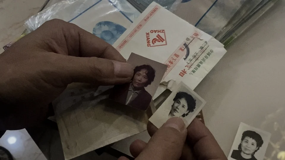 手中翻看的旧照片与证件
